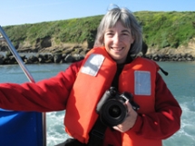 Debbie at a lake, holding a camera