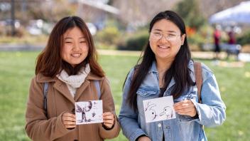Two people pose with watercolors they created at an Arboretum and Public Garden exhibit at Biodiversity Museum Day