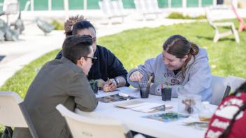 Three visitors watercolor at an Arboretum and Public Garden exhibit at Biodiversity Museum Day