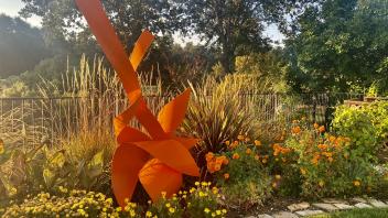 Sculpture among yellow and orange flowers