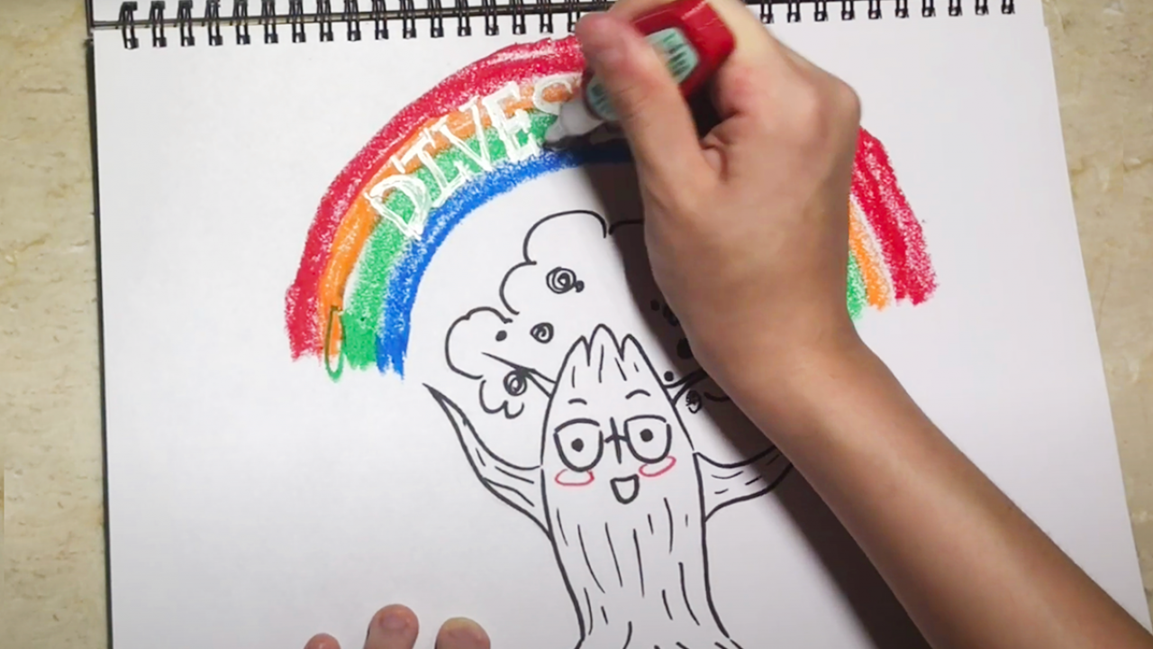 Image of a hand drawing an oak tree with a rainbow above it.