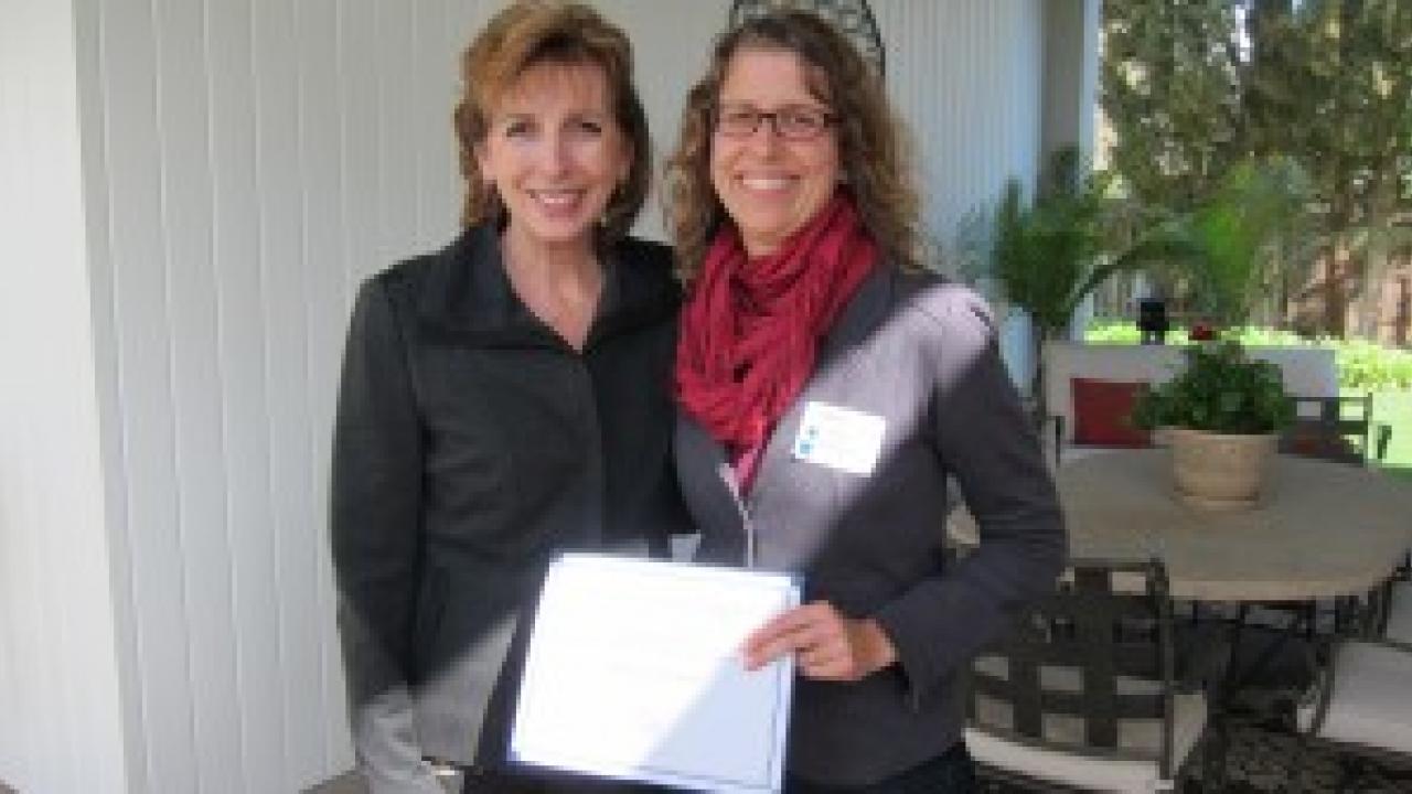 Linda Katehi and Emily Griswold holding award