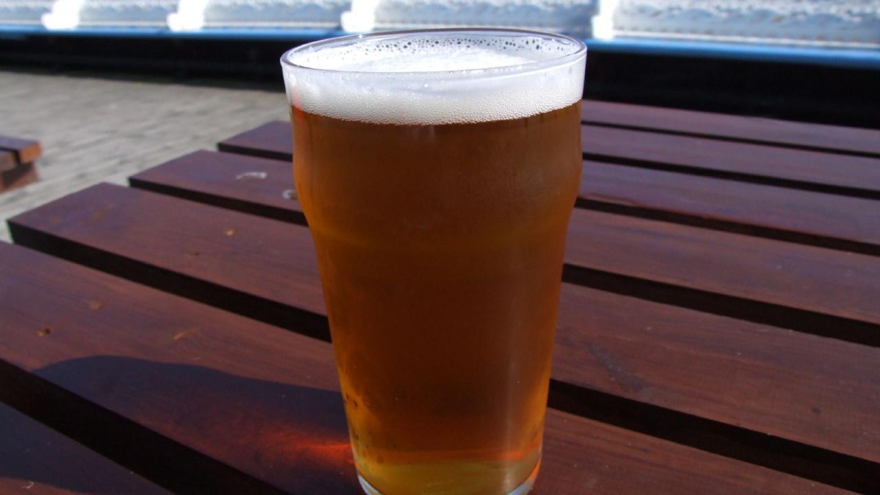 Image of a pint beer on a picnic table.