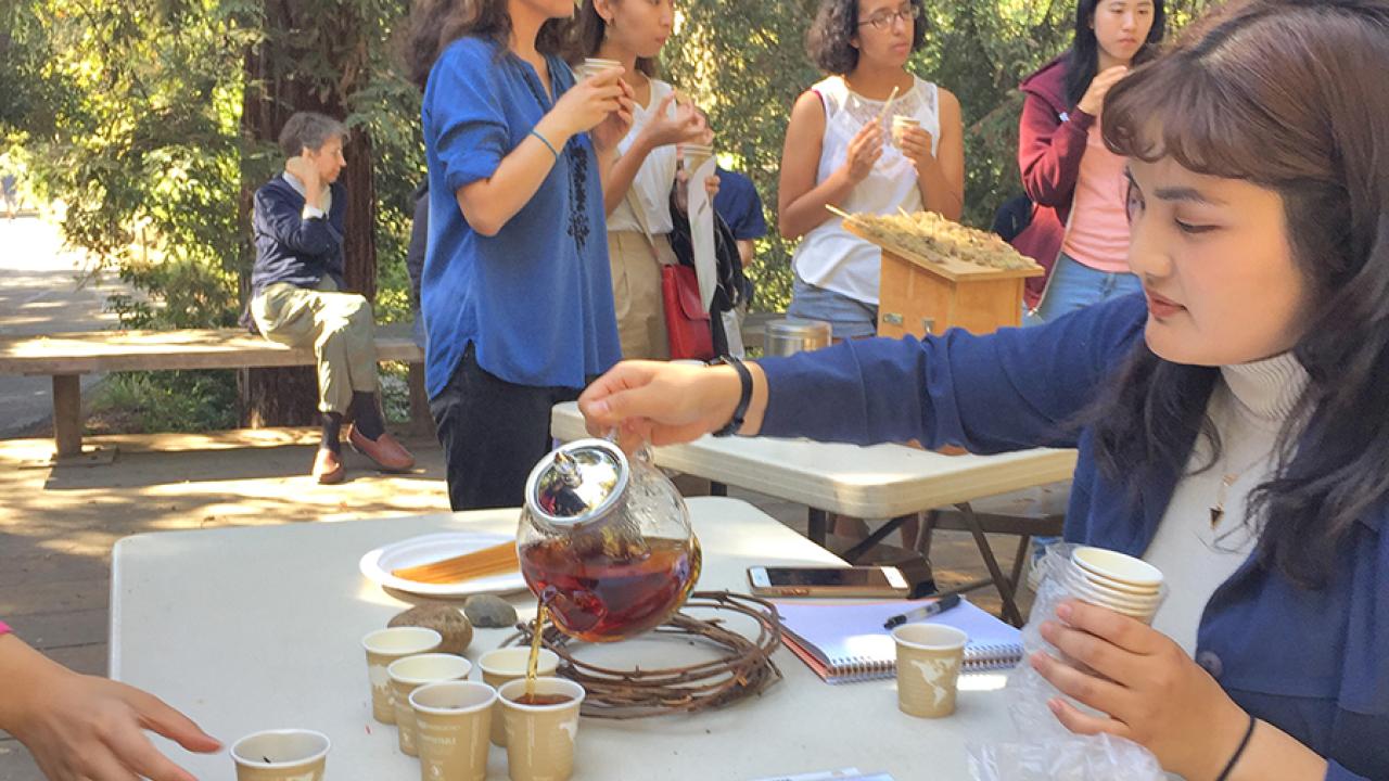 Image of woman pouring tea on Wyatt Deck.