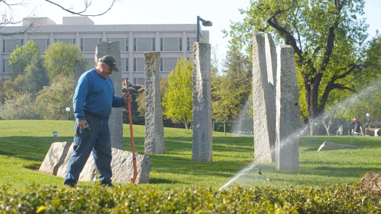 Member of the Grounds crew operates a sprinkler