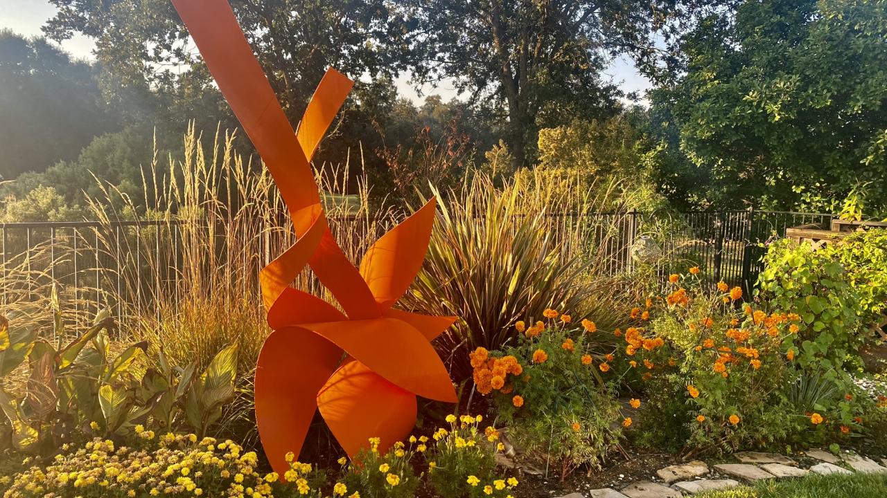 Sculpture among yellow and orange flowers