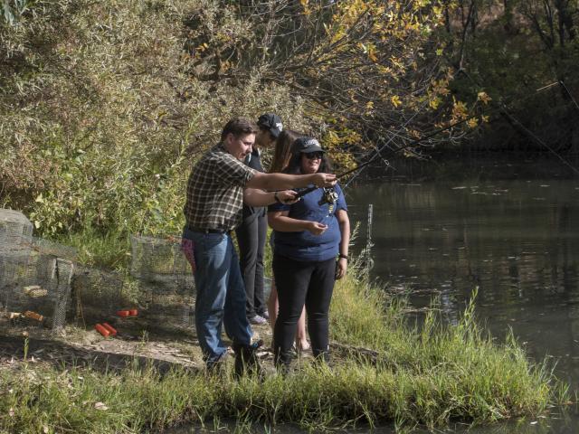 Image of students being taught how to fish at UC Davis Putah Creek Riparian Reserve.