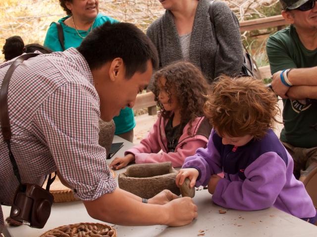 Image of UC Davis student teaching a young participant at one of the many free public programs offered by the UC Davis Arboretum and Public Garden.