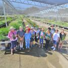 Image of students, staff and volunteers posing with plants in the UC Davis Arboretum Teaching Nursery.