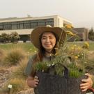 Image of Elizabeth Hursh with a potted plant for pollinators.