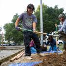 3 people use shovels to prepare an area for a tree planting