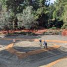 Three people work in a drained Arboretum Waterway