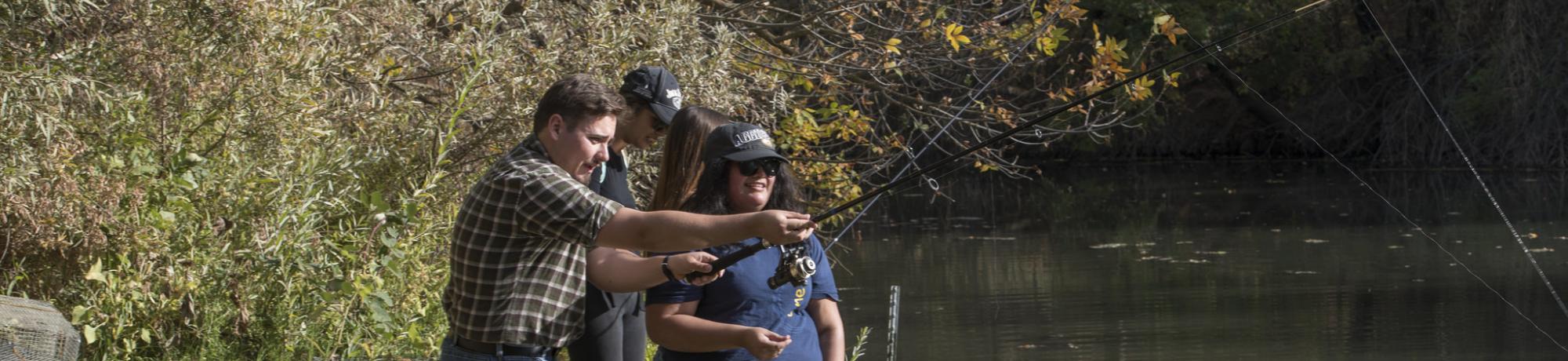 Image of students being taught how to fish at UC Davis Putah Creek Riparian Reserve.